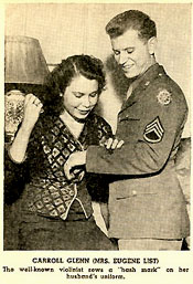 Sergeant (pianist) Eugene List with his wife, violinist Carroll Glenn, who sews a  "hash mark" on her husband's uniform.